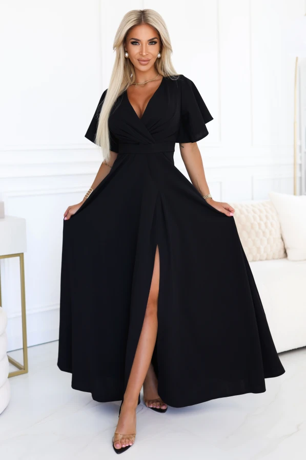 Modelka w eleganckiej czarnej sukni maxi z kopertowym dekoltem i rozcięciem na nodze, prezentująca wieczorową stylizację od polskiego producenta sukienek Numoco.