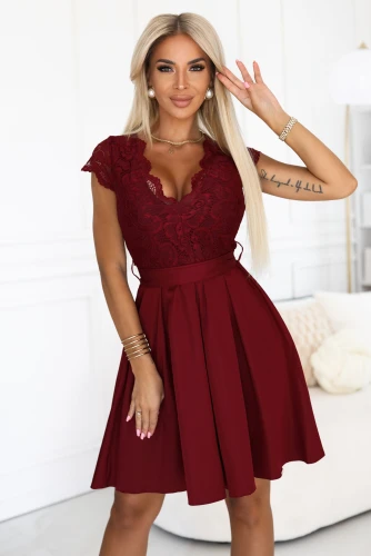 Modelka w bordowej sukience Anna marki Numoco z koronkową górą i rozkloszowanym dołem, idealnej na wesela, przyjęcia i eleganckie uroczystości.}