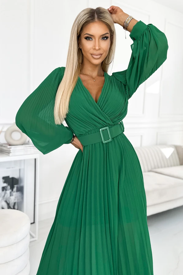Елегантна зелена плисирана рокля с дълги ръкави и колан, подчертаваща талията. Материята е лека и ефирна, идеална за специални поводи.