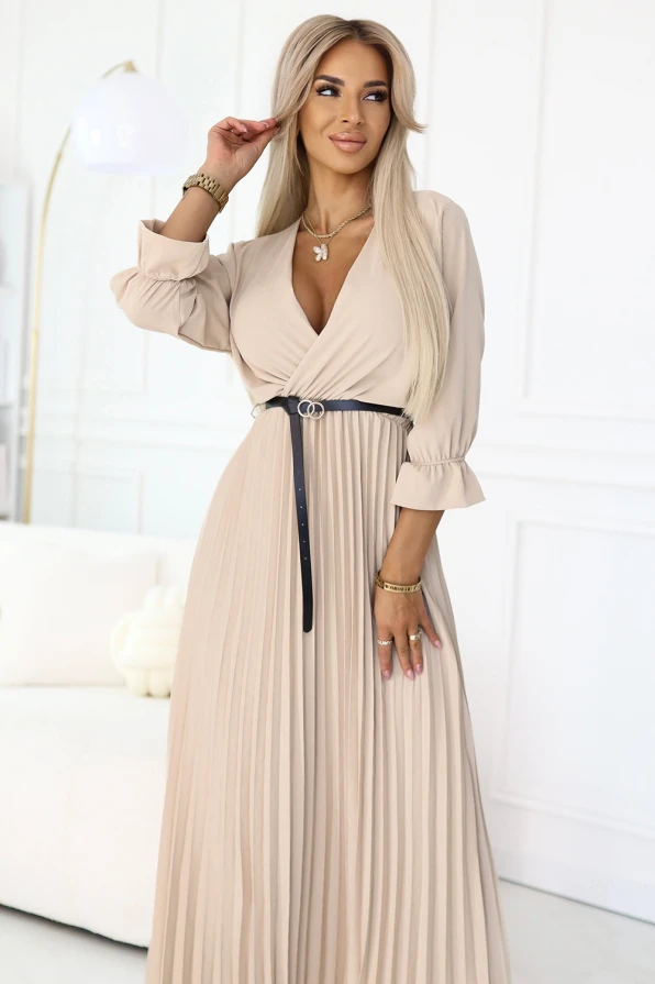 Modelka w beżowej plisowanej sukience maxi z kopertowym dekoltem i paskiem w talii – idealna na wesele, chrzciny, przyjęcia rodzinne, do pracy lub na elegancką kolację.