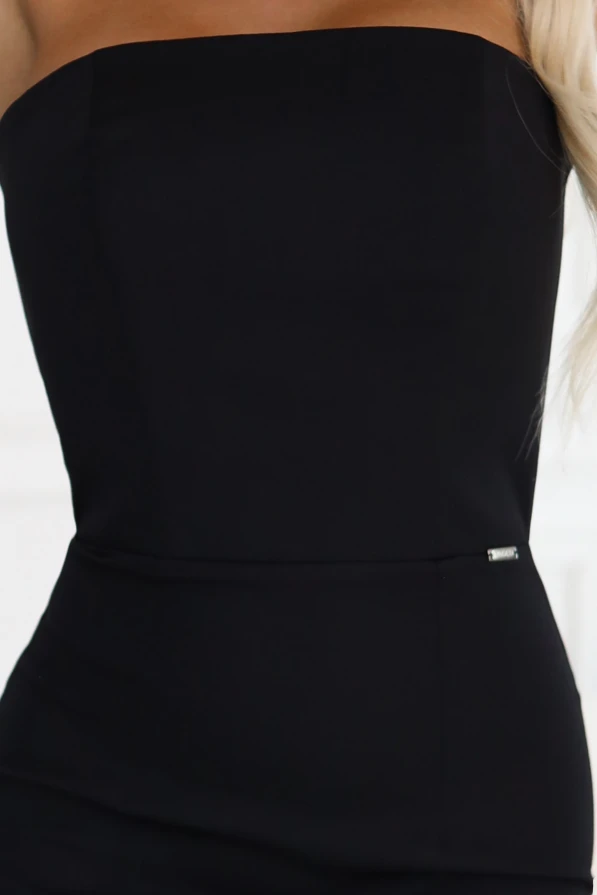 Modelka w klasycznej sukience midi Claudine marki Numoco – elegancka czarna kreacja bez ramiączek podkreślająca kobiecą sylwetkę.